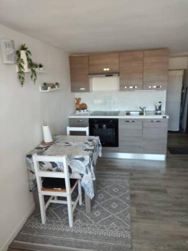 une cuisine avec une table et une cuisine avec une cuisinière dans l'établissement Studio 30 m 2, vue Mer avec Terrasse, à Cagnes-sur-Mer
