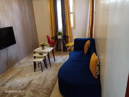 ein Wohnzimmer mit einem blauen Sofa und einem Tisch in der Unterkunft Monalissa One bedroom apartment in Kisumu