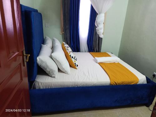 a bedroom with a bed with pillows and a window at Monalissa One bedroom apartment in Kisumu