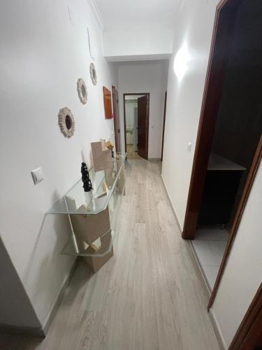a hallway with a glass table in a room at Quarto Suite Relaxante in Almada