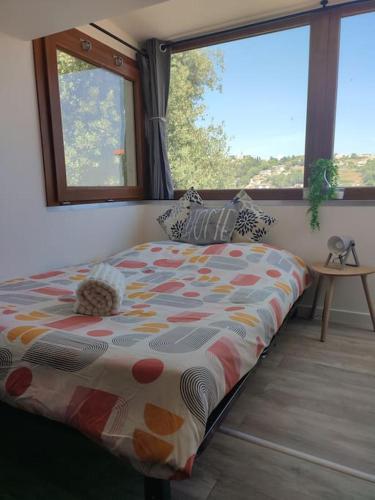 Ce lit se trouve dans un dortoir doté de 2 grandes fenêtres. dans l'établissement Studio 30 m 2, vue Mer avec Terrasse, à Cagnes-sur-Mer