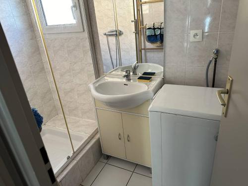 une salle de bain avec un lavabo et une douche dans l'établissement HOLIDAYLAND 137 VILLA T3 MEZZANINE 7 couchages climatisé NARBONNE PLAGE, à Narbonne-Plage