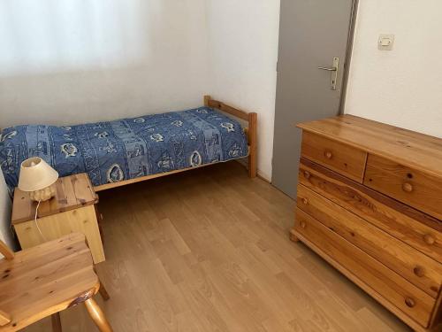 une chambre avec un lit et une commode en bois dans l'établissement HOLIDAYLAND 137 VILLA T3 MEZZANINE 7 couchages climatisé NARBONNE PLAGE, à Narbonne-Plage