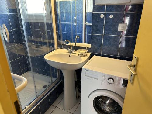 une salle de bain avec un lavabo et une machine à laver dans l'établissement HOLIDAYLAND 122 VILLA T3 MEZZANINE 7 couchages climatisé NARBONNE PLAGE, à Narbonne-Plage