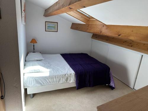 une petite chambre avec un lit dans un grenier dans l'établissement HOLIDAYLAND 122 VILLA T3 MEZZANINE 7 couchages climatisé NARBONNE PLAGE, à Narbonne-Plage