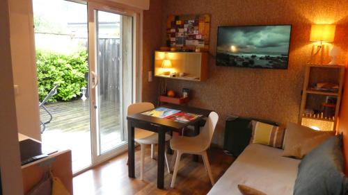 un salon avec une table et un canapé dans l'établissement T2 au calme avec terrasse sur le bassin d'Arcachon, à Gujan-Mestras