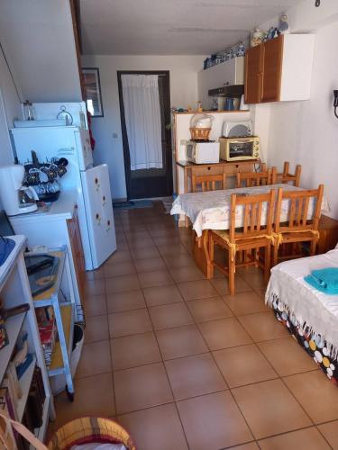 Il dispose d'une cuisine avec une table et des chaises. dans l'établissement HOLIDAYLAND CALAMAR PAVILLON T2 6 couchages climatisé Narbonne Plage, à Narbonne-Plage