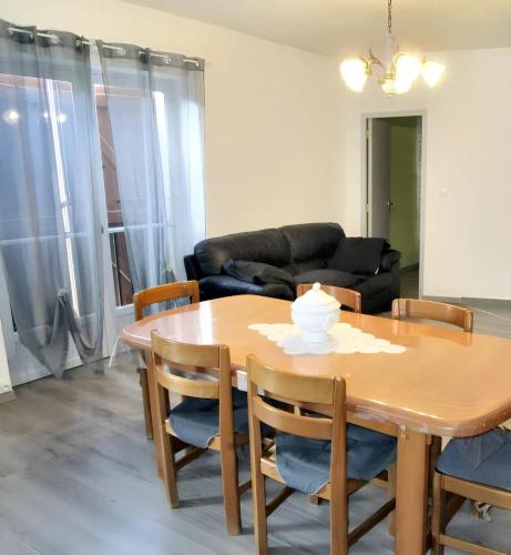 un salon avec une table et des chaises en bois dans l'établissement Maison champêtre à Tournissan avec grand jardin, à Tournissan
