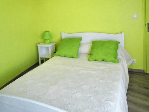 una camera da letto con un letto bianco con pareti verdi di Maison champêtre à Tournissan avec grand jardin a Tournissan