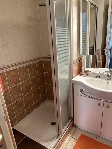 y baño con ducha y lavamanos. en HOLIDAYLAND 432 VILLA T2 MEZZANINE 6 couchages climatisé avec véranda et Box internet NARBONNE PLAGE, en Narbonne-Plage