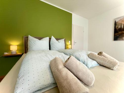 a bedroom with a large bed with a green wall at Parkside City Apartment - Leipzig Zentrum - Netflix in Leipzig
