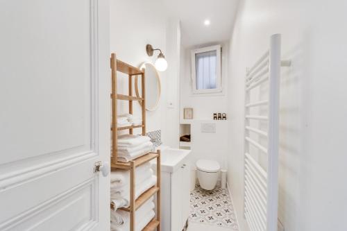 une salle de bain blanche avec des toilettes et un lavabo dans l'établissement Confort et Charme en Centre-Ville - Proche Gare, à Pantin