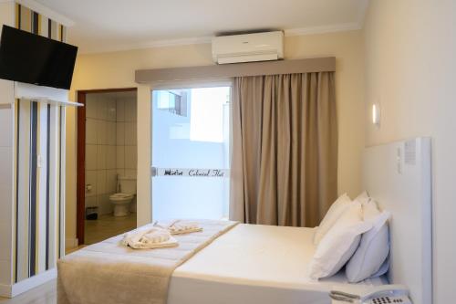 a hotel room with a bed with towels on it at Colonial Flat Hotel in Itapetininga