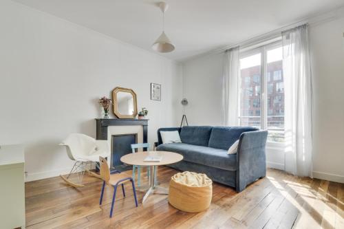 un salon avec un canapé bleu et une table dans l'établissement Confort et Charme en Centre-Ville - Proche Gare, à Pantin