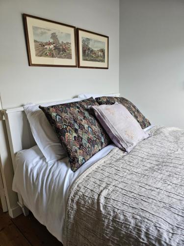 a bed with two pillows on it in a bedroom at Logeerderij tussen Koe & Kroonluchter in Diessen