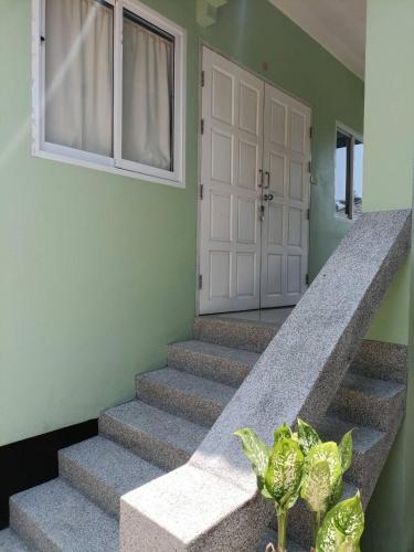 a staircase with a white door and a plant at Wasin House One Bedroom - Maenum in Mae Nam