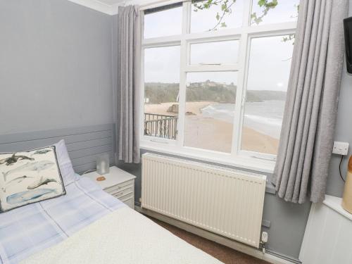 テンビーにあるApartment 4のベッドルーム1室(ベッド1台付)、ビーチの景色を望む窓が備わります。