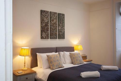 a bedroom with a bed with two lamps on two tables at ※ Stunning, Bath Townhouse, City Centre (AS) ※ in Bath