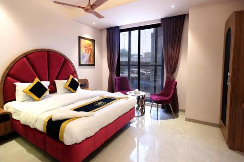 a bedroom with a large bed with a red headboard at Hotel A R Paradise in Mire