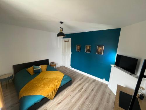 une chambre avec un lit et un mur bleu dans l'établissement La vintage ETRETAT, à Fécamp