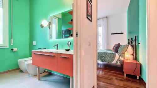 フォルリにあるRomagnaBNB Il Passatoreの緑の壁のバスルーム(赤い洗面化粧台付)