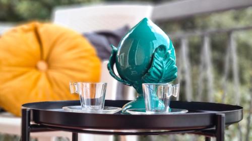 a black table with two glasses and a green vase at Il Passatore in Forlì