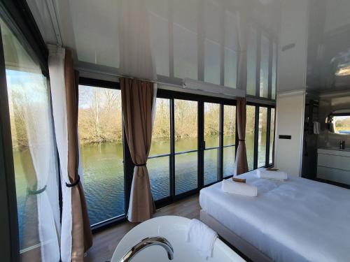 a bedroom with two beds and a large window at Escale Royale Saint Jean de Losne 35' de Dijon House Boat sur l'eau in Saint-Jean-de-Losne