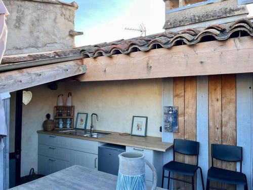 - une cuisine avec un évier, une table et des chaises dans l'établissement 