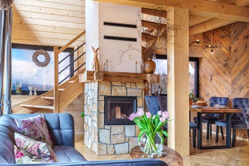 a living room with a fireplace and a table at Alpen House in Dursztyn