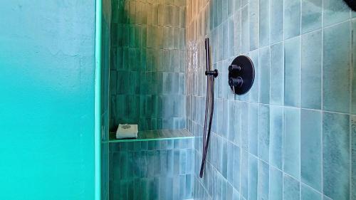 a shower in a bathroom with blue tiles at Il Passatore in Forlì