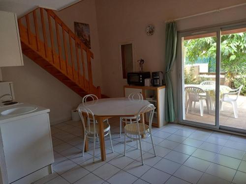 Il dispose d'un balcon et d'une cuisine avec une table et des chaises. dans l'établissement HOLIDAYLAND 212 VILLA T2 MEZZANINE 6 couchages climatisé NARBONNE PLAGE, à Narbonne-Plage