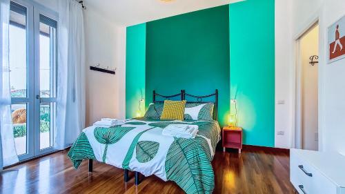 a bedroom with a green accent wall and a bed at Il Passatore in Forlì