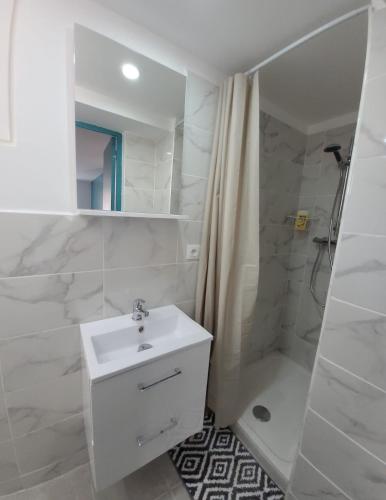 une salle de bain blanche avec un lavabo et une douche dans l'établissement Charment T2 quartier créateurs,Métro Crs julien., à Marseille