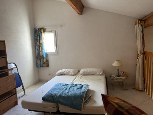 une chambre avec un lit et une fenêtre dans l'établissement HOLIDAYLAND 318 VILLA T2 MEZZANINE 4 couchages climatisé avec véranda NARBONNE PLAGE, à Narbonne-Plage