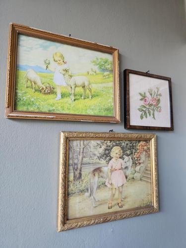 three framed pictures on a wall with a girl and a painting at Logeerderij tussen Koe & Kroonluchter in Diessen
