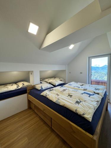 a bedroom with two beds and a window at Špan Cottage in Jesenice