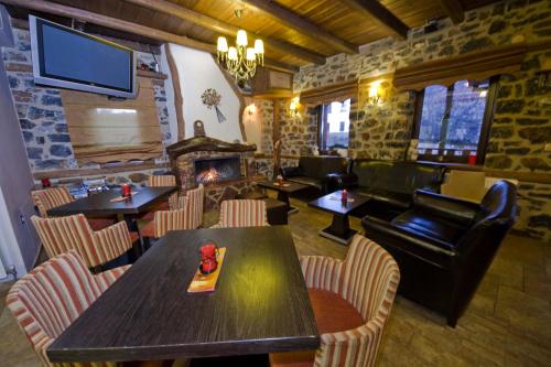 a restaurant with a table and chairs and a fireplace at Guesthouse Elati - Pella in Palaios Agios Athanasios