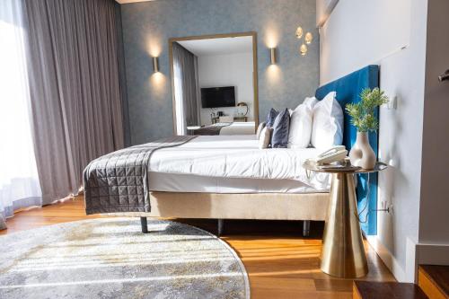 a bedroom with a large bed and a mirror at Pestana Cidadela Cascais - Pousada & Art District in Cascais