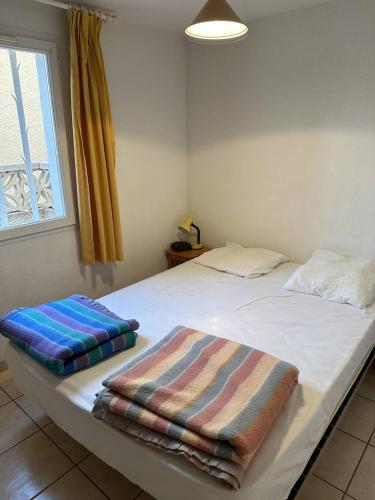 um quarto com uma cama com duas toalhas em HOLIDAYLAND 420 VILLA T3 MEZZANINE 8 couchages climatisé NARBONNE PLAGE em Narbonne Plage