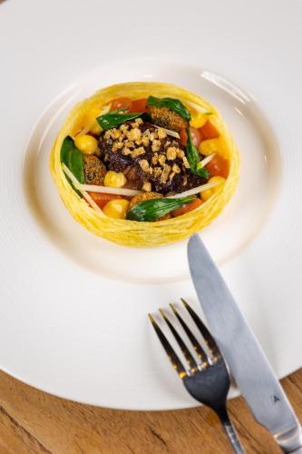 a bowl of food on a plate with a fork and knife at The Northumberland Arms in West Thirston