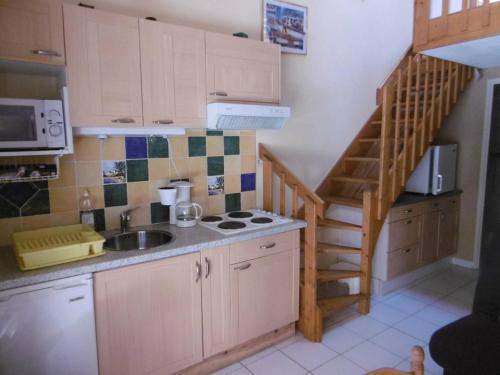 une petite cuisine avec un évier et un escalier dans l'établissement HOLIDAYLAND 224 VILLA T2 MEZZANINE 7 couchages climatisé NARBONNE PLAGE, à Narbonne-Plage