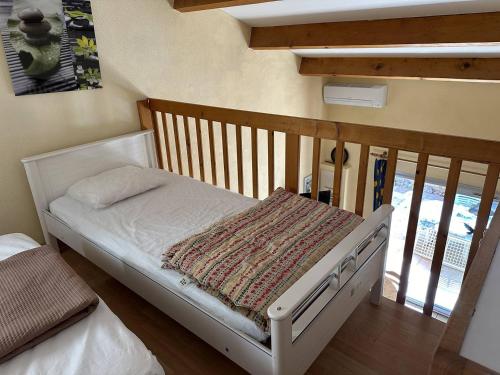 - un petit lit bébé dans l'établissement HOLIDAYLAND 224 VILLA T2 MEZZANINE 7 couchages climatisé NARBONNE PLAGE, à Narbonne-Plage