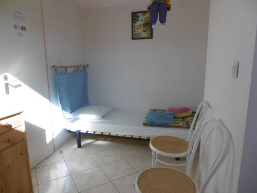 a small room with a bed and two chairs at HOLIDAYLAND 401 VILLA T3 MEZZANINE 7 couchages climatisé NARBONNE PLAGE in Narbonne-Plage