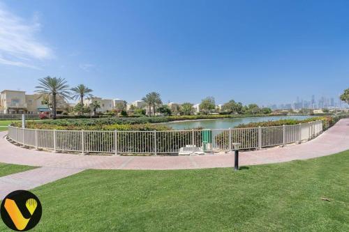 a fence in a park next to a body of water at Vogue Villa Near Golf/Ski Dubai/ Ibn Battuta Mall in Dubai