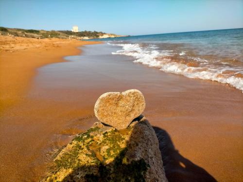 a heart sitting on a rock on the beach at Re Mare B&B in Crotone