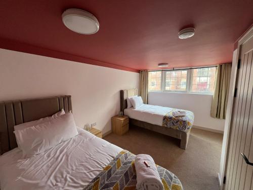 1 dormitorio con 2 camas y ventana en Fully Furnished Medway with FREE PARKING by Prescott Apartments, en Bristol