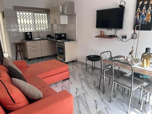 uma sala de estar com um sofá, uma mesa e uma cozinha em Impeccable 1-Bed House in Kweiman Station danfa em Danfa