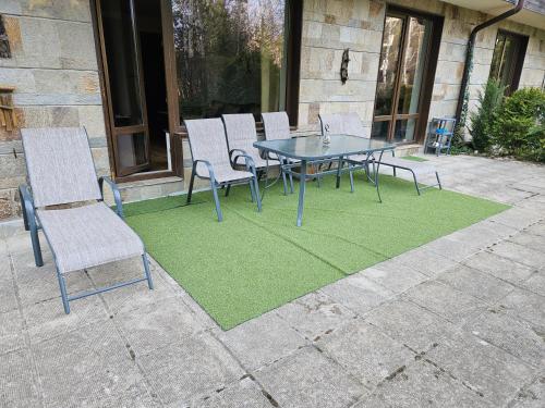 a table and chairs on a patio with a green rug at TERRA KOMPLEX D3 - Private apartment - Golf, Skiing & SPA in Razlog