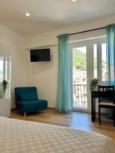 - une chambre avec une chaise bleue et une fenêtre dans l'établissement B&B Terzo Piano, à Cava deʼ Tirreni