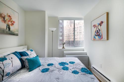 een witte slaapkamer met een bed en een raam bij Luxurious 2 BR Apartment in New York in New York